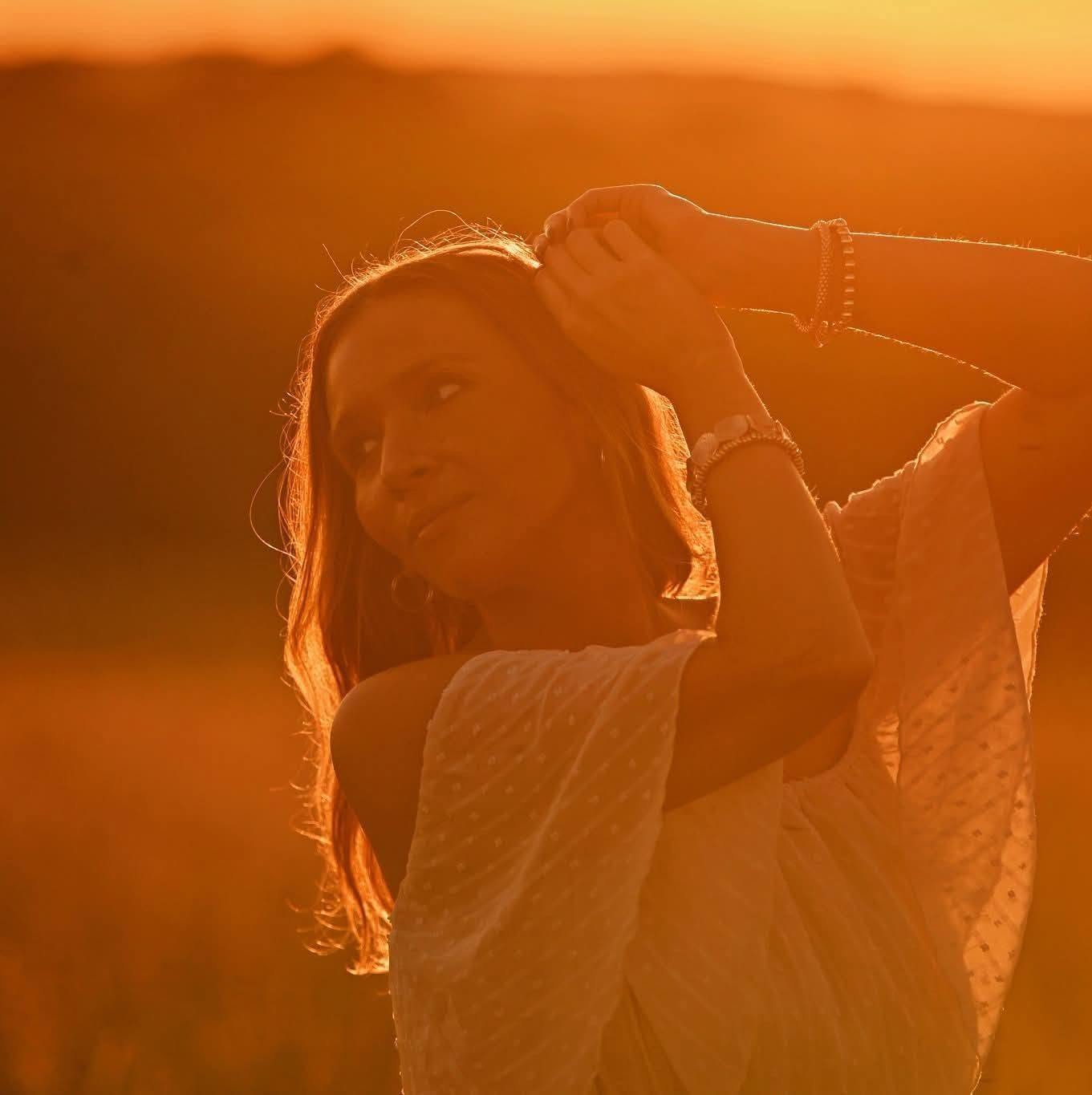 Golden hour portrait of a woman in a field, photographed by Kiley Tritz